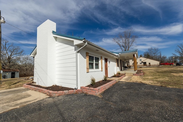 view of side of property featuring brick siding and a chimney