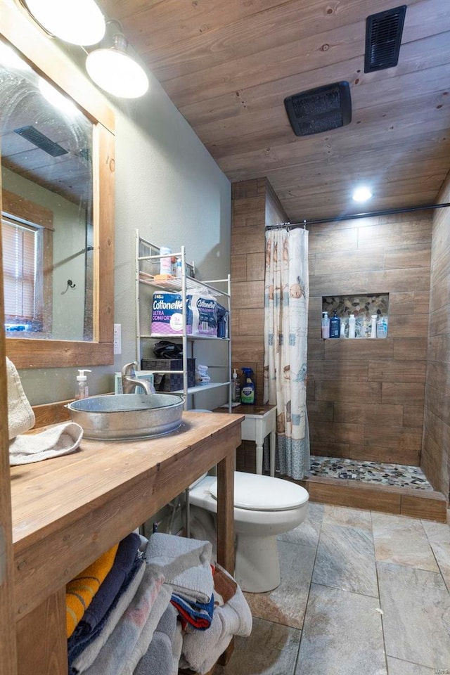 bathroom featuring wooden ceiling, curtained shower, toilet, and sink