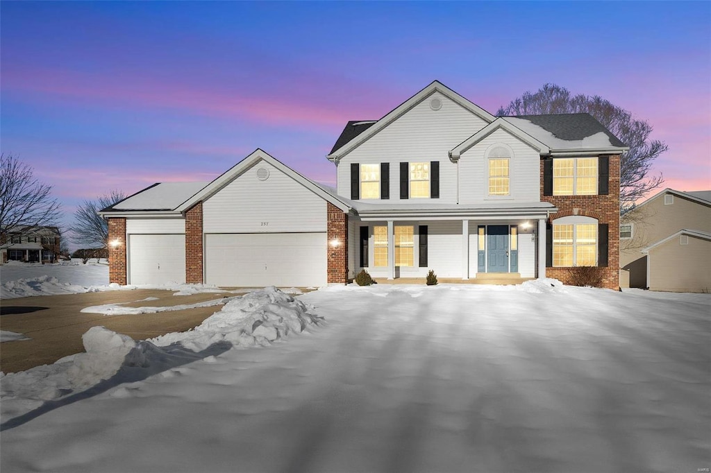 front facade with covered porch and a garage