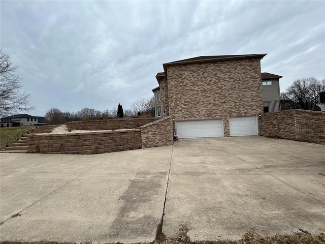 view of side of property featuring driveway and an attached garage