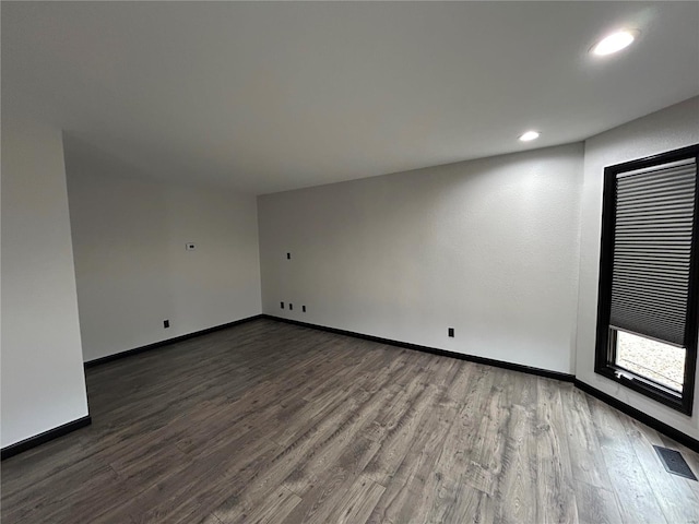 empty room with baseboards, visible vents, wood finished floors, and recessed lighting