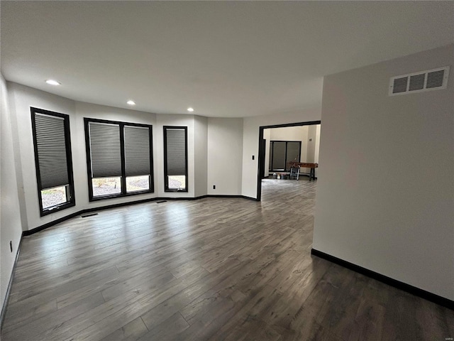 unfurnished room featuring dark wood-style floors, recessed lighting, visible vents, and baseboards