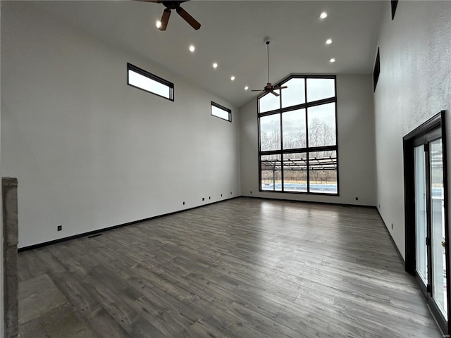 unfurnished room with dark wood finished floors, recessed lighting, a ceiling fan, high vaulted ceiling, and baseboards