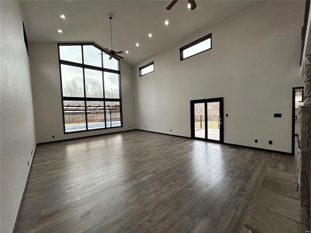 spare room with a ceiling fan, dark wood finished floors, and plenty of natural light