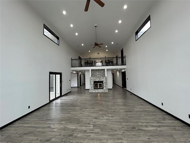 unfurnished living room featuring a ceiling fan, a fireplace, and wood finished floors