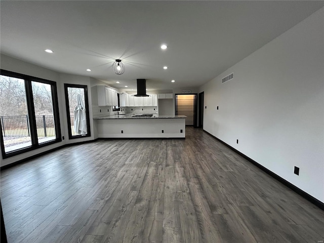 unfurnished living room with dark wood-style floors, recessed lighting, visible vents, and baseboards