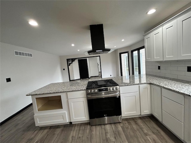 kitchen with dark wood-style flooring, stainless steel gas stove, visible vents, and island range hood