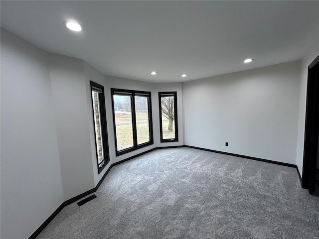 empty room featuring recessed lighting, carpet flooring, visible vents, and baseboards