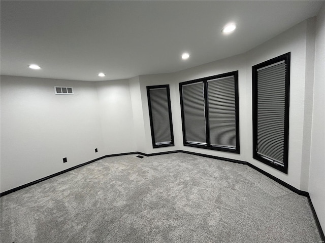 carpeted empty room featuring baseboards, visible vents, and recessed lighting