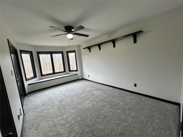 carpeted spare room with a baseboard radiator, baseboards, and a ceiling fan