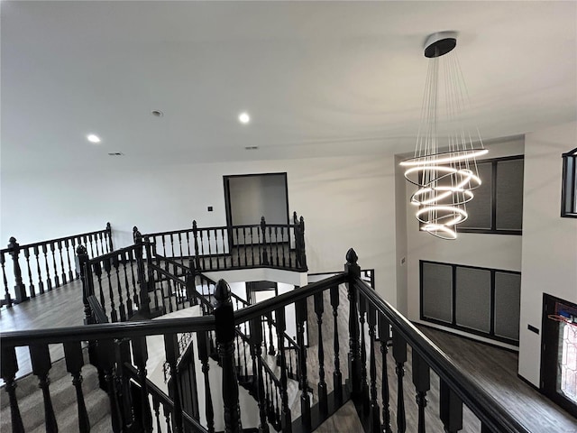 corridor featuring recessed lighting, a notable chandelier, and an upstairs landing