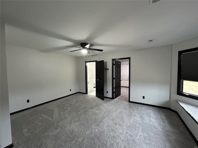 unfurnished bedroom featuring carpet floors, visible vents, baseboards, and ceiling fan