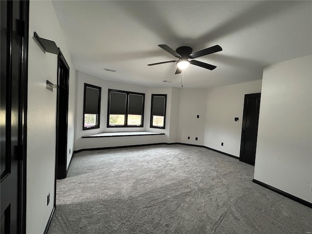 unfurnished room with a ceiling fan, carpet flooring, visible vents, and baseboards