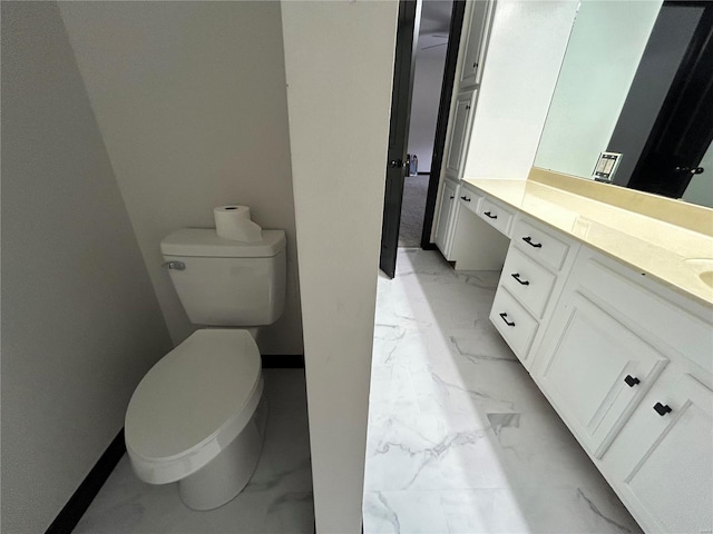 bathroom with marble finish floor, baseboards, vanity, and toilet