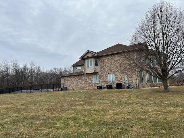 view of property exterior with fence, cooling unit, and a yard