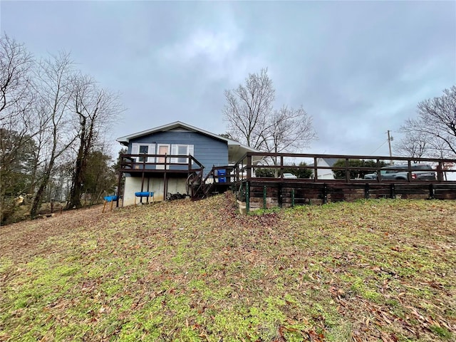 rear view of property featuring a wooden deck