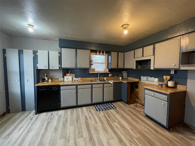 kitchen featuring dishwasher, sink, gray cabinetry, a textured ceiling, and light hardwood / wood-style flooring