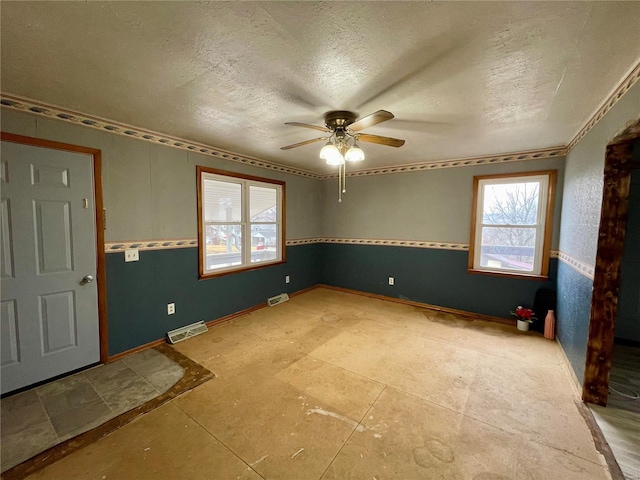 unfurnished room featuring ceiling fan and a textured ceiling