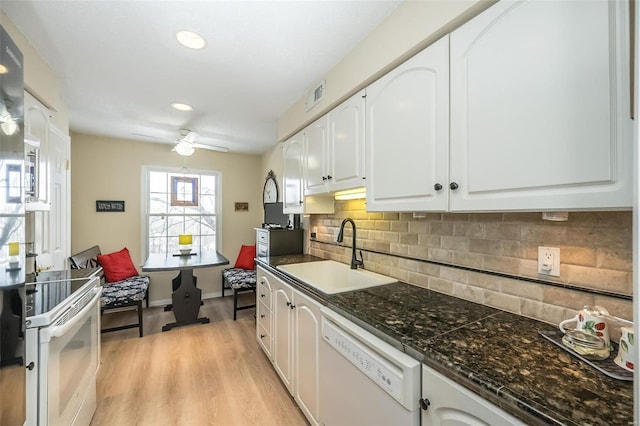 kitchen featuring white appliances, light hardwood / wood-style floors, white cabinetry, decorative backsplash, and sink