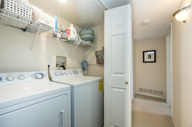 laundry area featuring light carpet and separate washer and dryer