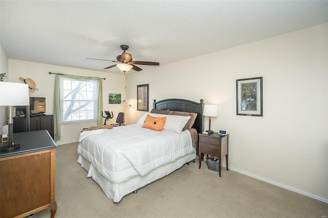 bedroom with ceiling fan, a textured ceiling, and light carpet