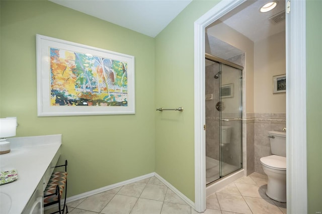 bathroom featuring walk in shower, vanity, toilet, and tile patterned flooring