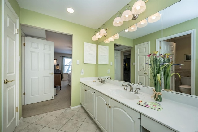 bathroom with toilet, tile patterned flooring, and vanity