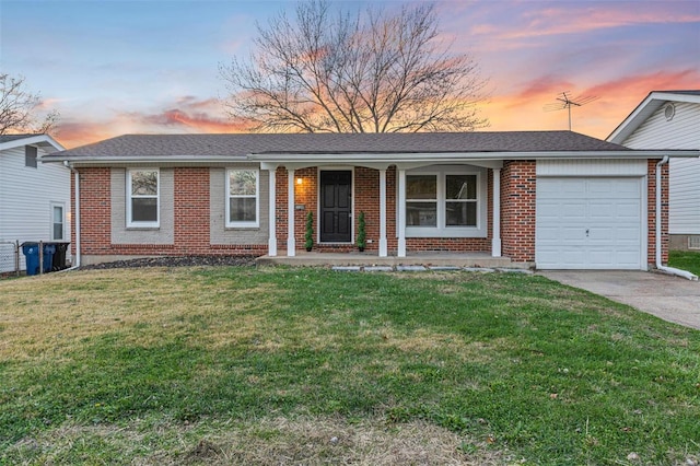 single story home featuring a garage and a lawn