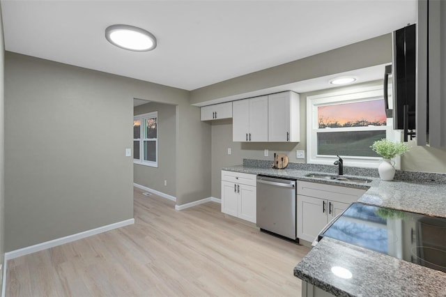 kitchen featuring white cabinetry, light wood-type flooring, dishwasher, light stone countertops, and sink