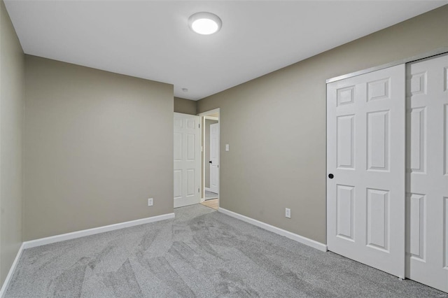 unfurnished bedroom featuring light carpet and a closet