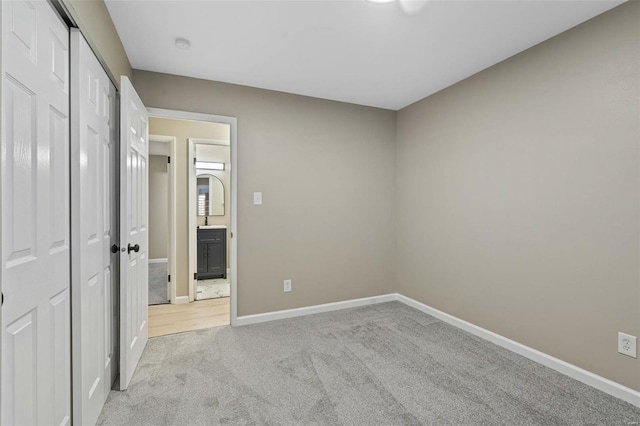 unfurnished bedroom featuring a closet and light colored carpet