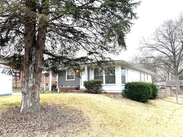 view of front facade with a garage, a front yard, and fence