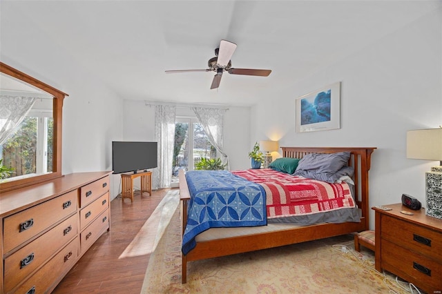 bedroom with ceiling fan, hardwood / wood-style floors, multiple windows, and access to outside