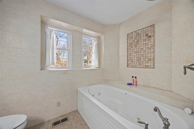 bathroom featuring tile walls, tile patterned floors, a tub, and toilet