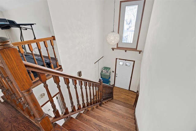 stairway featuring an inviting chandelier and hardwood / wood-style floors