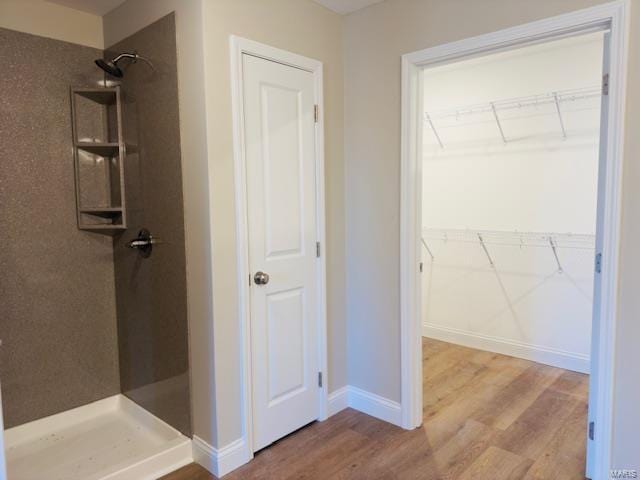 bathroom with a shower and hardwood / wood-style floors