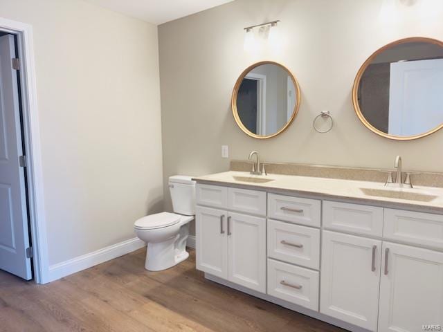 bathroom featuring toilet, hardwood / wood-style floors, and vanity