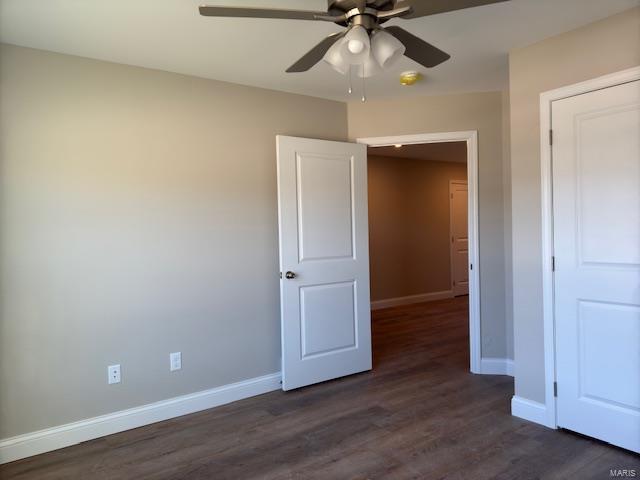 unfurnished bedroom featuring ceiling fan and dark hardwood / wood-style flooring