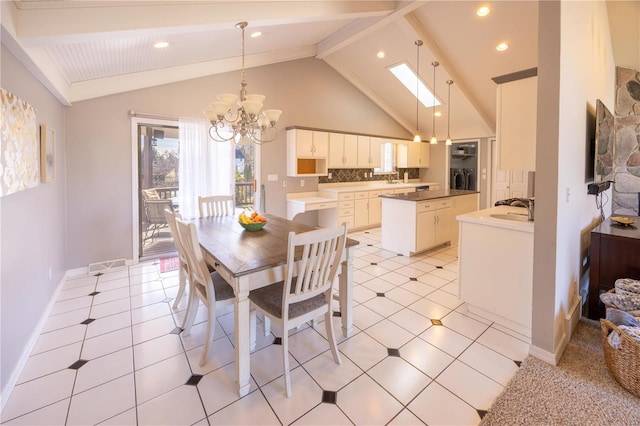 dining area featuring sink, beam ceiling, a skylight, high vaulted ceiling, and a chandelier