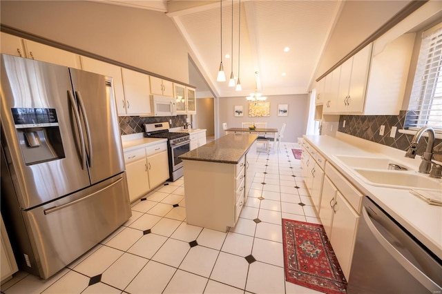 kitchen featuring pendant lighting, sink, lofted ceiling, stainless steel appliances, and a center island