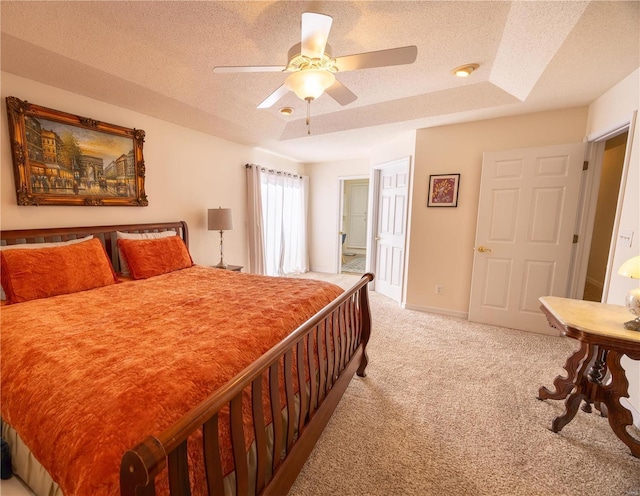 carpeted bedroom featuring ceiling fan and a textured ceiling