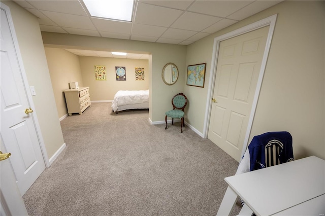 carpeted bedroom featuring a drop ceiling