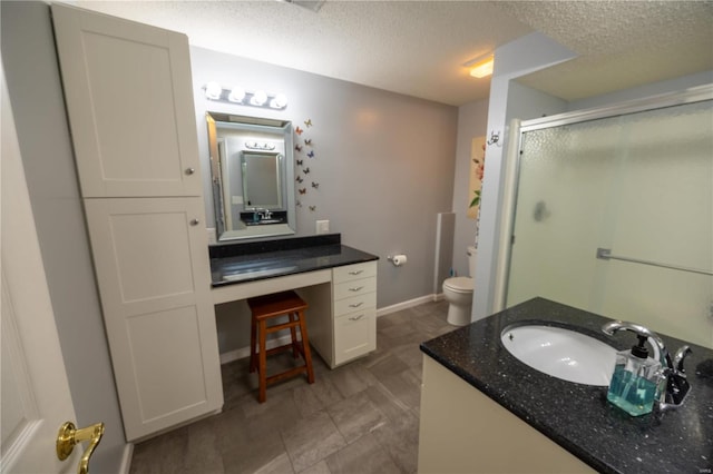 bathroom featuring walk in shower, vanity, toilet, and a textured ceiling