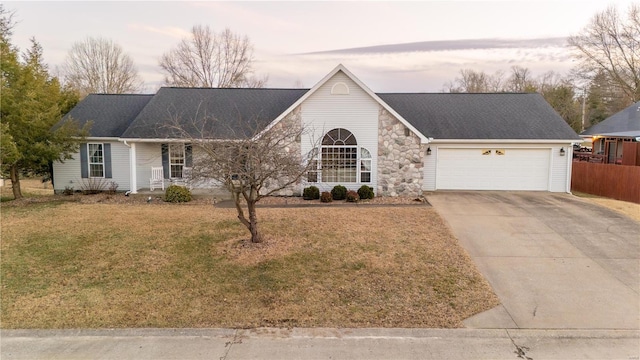 single story home with a garage and a lawn