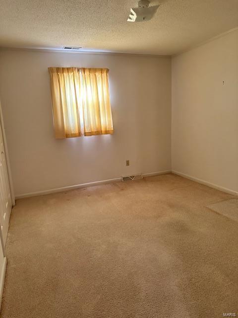 unfurnished room with carpet floors and a textured ceiling