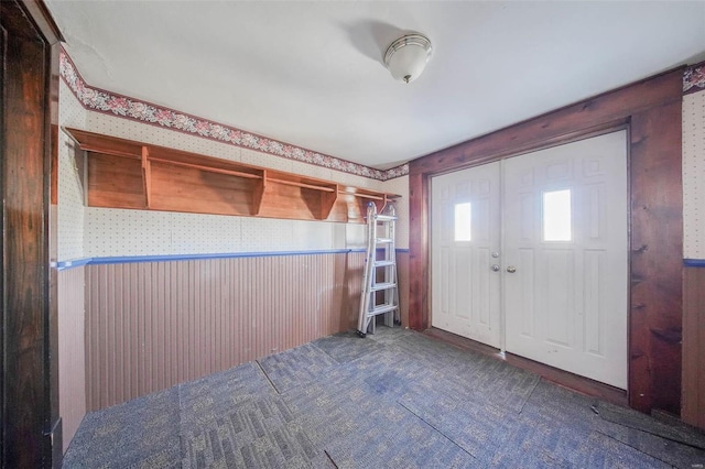 entryway featuring wood walls