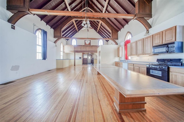 kitchen featuring wood ceiling, beam ceiling, high vaulted ceiling, and black appliances