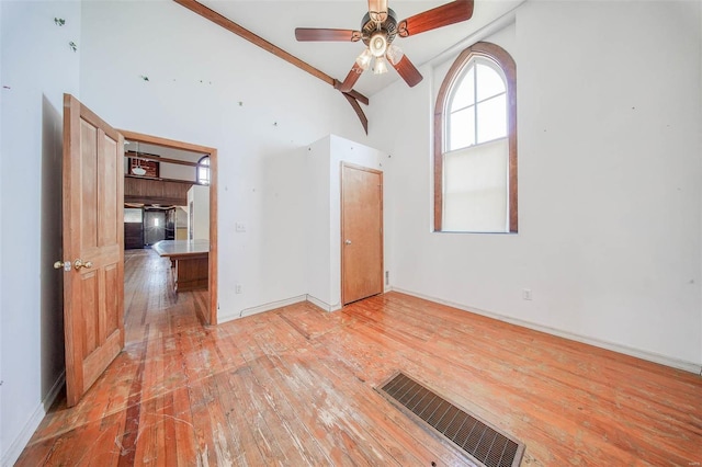 spare room with high vaulted ceiling, ceiling fan, and light hardwood / wood-style floors