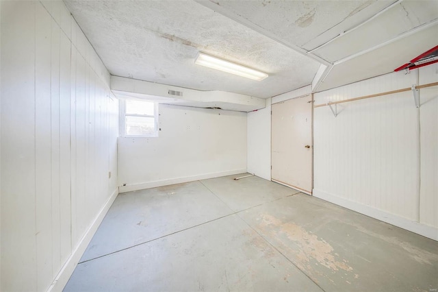 basement featuring wood walls