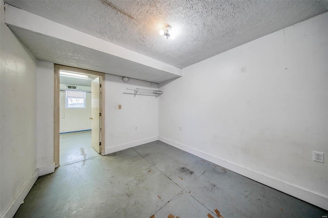 unfurnished room with a textured ceiling